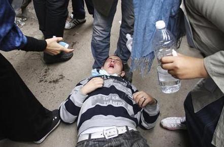 محتجون يسعفون رجلا استنشق غازا مسيلا للدموع قرب ميدان التحرير بالقاهرة أمس